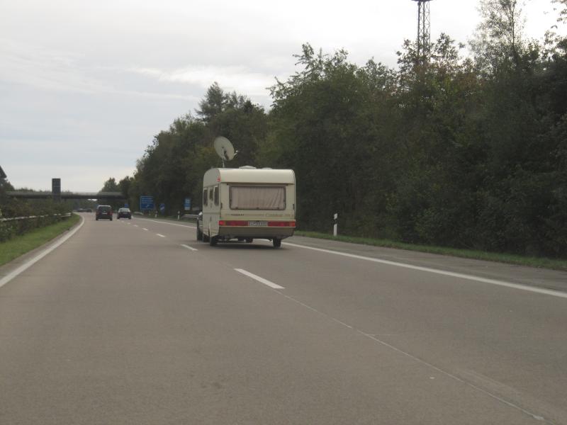 Caravan mit Satschüssel auf Autobahn